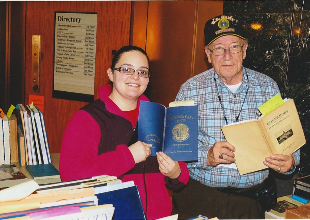 Photo by David Malhalab/M News Service Ardiana Ali (left) gets the soft sell from Michael Tate, curator of the Dearborn Historical Museum, that is selling a variety of paperback and hardcover books, periodicals, magazines, yearbooks and more at the Friends of Library Dearborn Book Sales March 1 at Henry Ford Centennial Library. Tate said those items do not fit into the museum’s collection, so they are made available to the public. Sales are held the first Wednesday of the month at HFCL; the next sale will be from 9:30 a.m. to 6 p.m. April 5. For more information, go to http://dearbornlibrary.org/wordpress/friends-of-the-library-of-dearborn.
