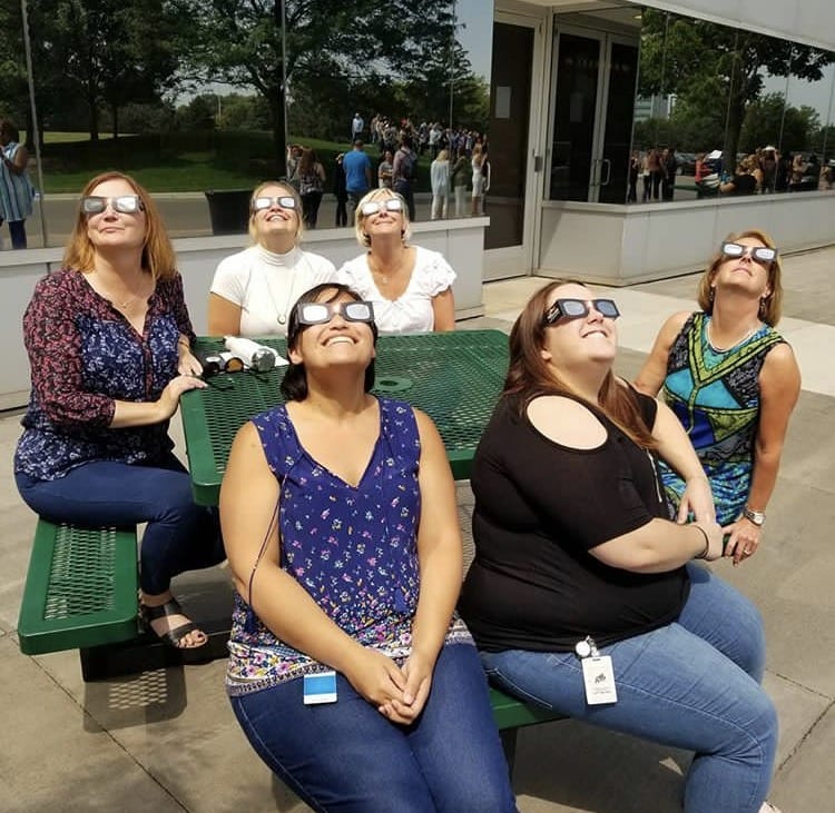 Photo by Dana Salayon Global Team Blue employees watch the total solar eclipse outside their office in Dearborn.
