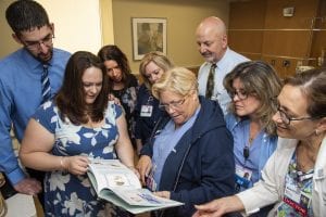 Photo courtesy of Beaumont Health Scott and Alison Duley (left) look through a book of their son William’s life, with Angela Winton (third from left), executive director, Metro Detroit Share; Darlene Bacyinski; Joyce Grignon; Dr. Derek Bair; Karen Andrysiak and Dr. Sara Garmel.